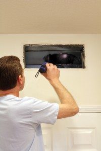 Man Looking Into Air Duct